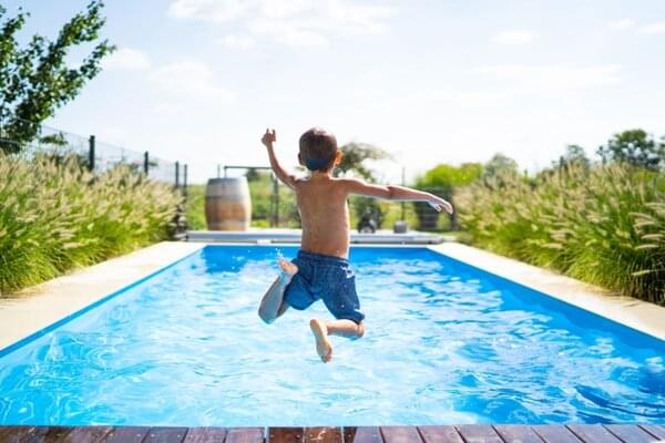 kid jumping into swimming pool