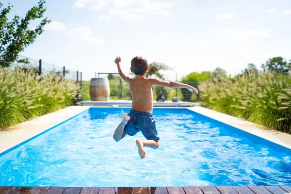 kid jumping into swimming pool